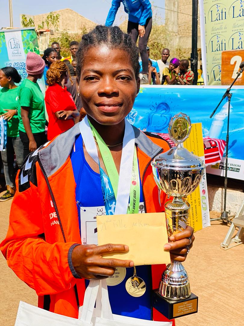 Lafi 10km Ouaga une coureuse qui présente ses médailles et son trophée